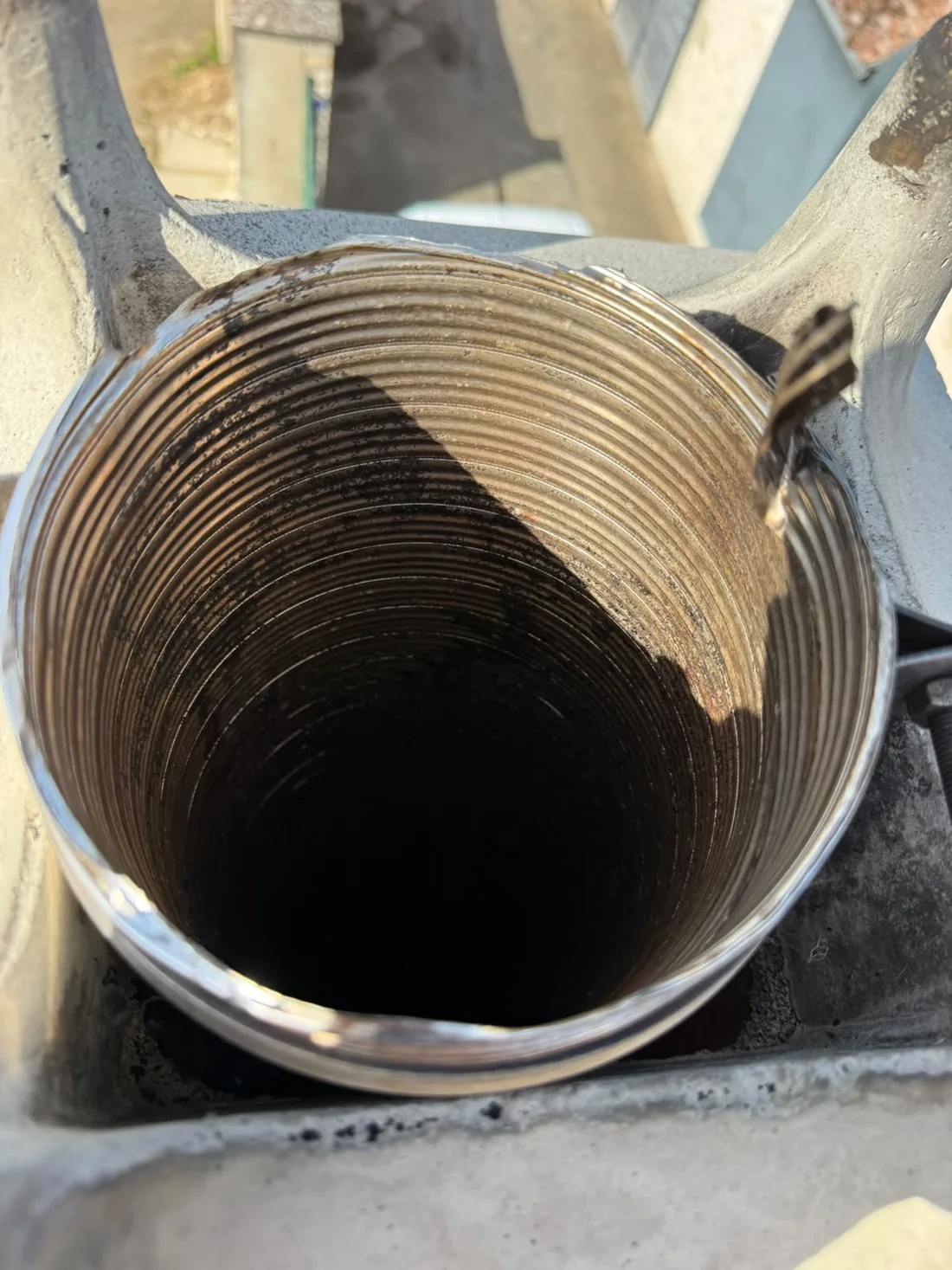 Tubage inox annelé vu depuis le débouché en toiture après ramonage, paroi nette sur toute la circonférence